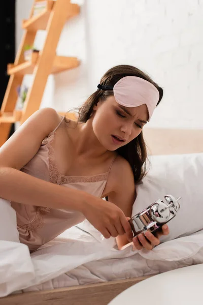 Mujer joven disgustado sosteniendo reloj despertador retro - foto de stock