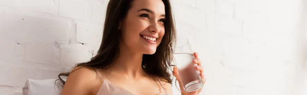 Panoramic shot of young woman holding glass with water — Stock Photo