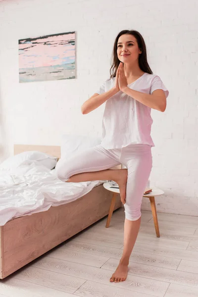Young and barefoot woman standing in prayer pose — Stock Photo