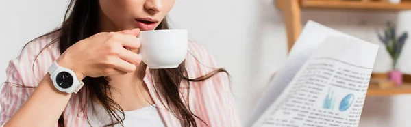 Panoramic crop of woman holding cup and newspaper — Stock Photo