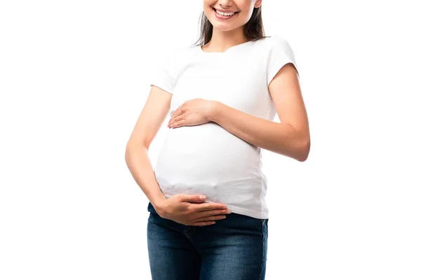 Abgeschnittene Ansicht einer schwangeren Frau in weißem T-Shirt, die Bauch isoliert auf weißem Grund berührt — Stockfoto