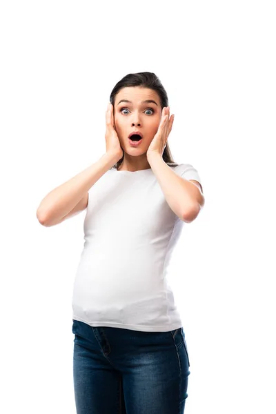 Femme enceinte choquée en t-shirt blanc regardant la caméra isolée sur blanc — Photo de stock