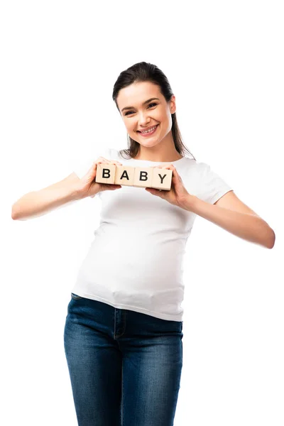 Jeune femme enceinte tenant des cubes en bois avec lettrage bébé isolé sur blanc — Photo de stock