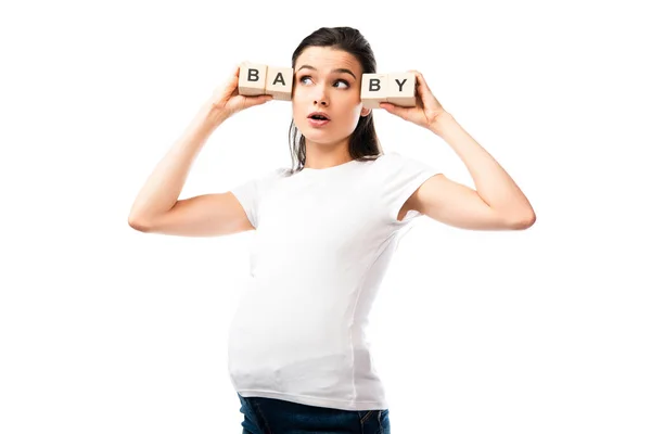 Jeune femme enceinte en t-shirt blanc tenant des cubes en bois avec lettrage bébé isolé sur blanc — Photo de stock