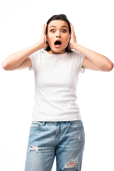 Mujer joven asustada en camiseta blanca mirando a la cámara aislada en blanco - foto de stock