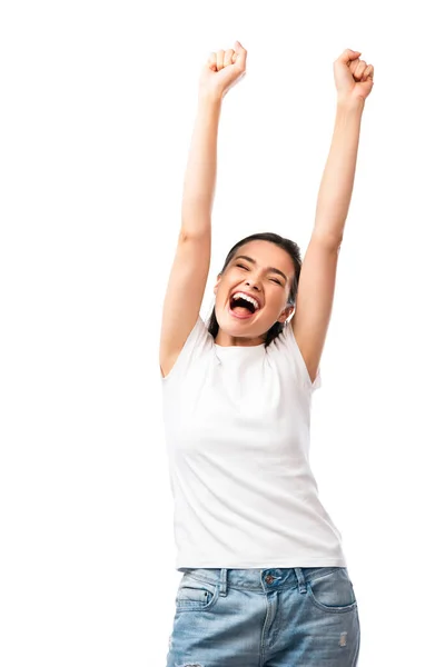 Excitée jeune femme en t-shirt blanc debout avec les mains au-dessus de la tête isolé sur blanc — Photo de stock
