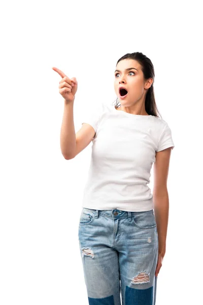 Шокированная молодая женщина в белой футболке, указывающая пальцем на белый — стоковое фото