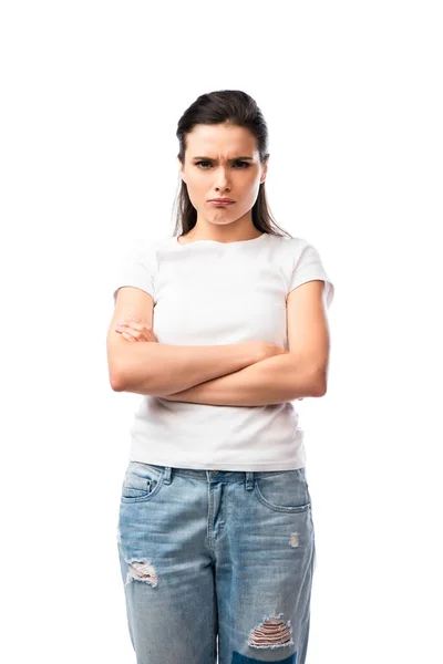 Оскорблённая женщина в белой футболке и джинсах стоящая со скрещенными руками изолированная на белом — стоковое фото