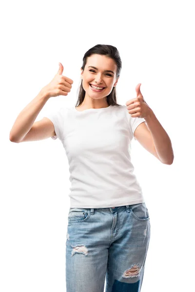 Mujer joven en camiseta blanca y pantalones vaqueros mostrando los pulgares hacia arriba aislado en blanco - foto de stock