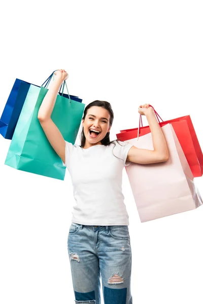 Femme brune avec bouche ouverte tenant des sacs à provisions isolés sur blanc — Photo de stock