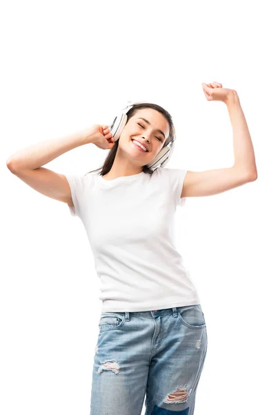 Mujer joven con los ojos cerrados en camiseta blanca y auriculares inalámbricos aislados en blanco - foto de stock