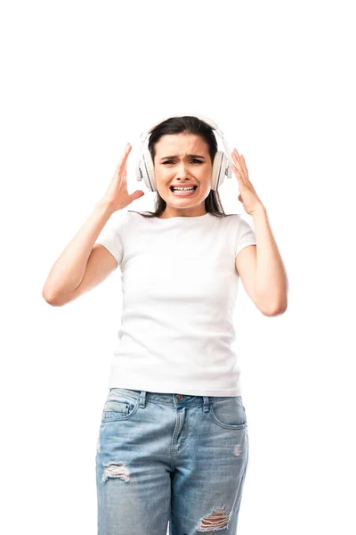 Напружена молода жінка в білій футболці і бездротових навушниках ізольовані на білому — стокове фото