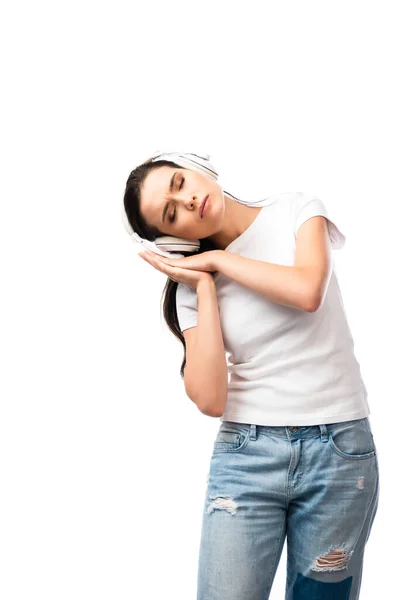 Mujer somnolienta con los ojos cerrados y auriculares inalámbricos aislados en blanco - foto de stock