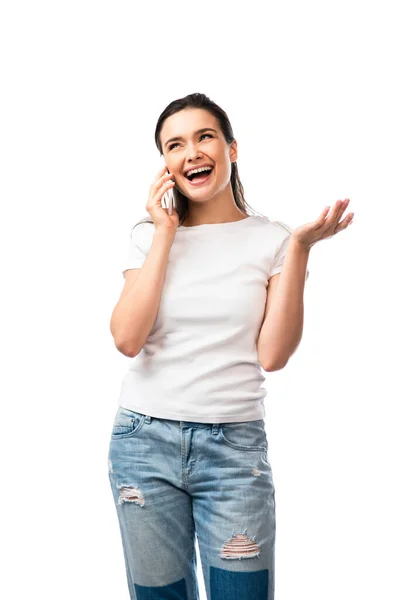 Mujer joven en camiseta blanca haciendo gestos y hablando en un teléfono inteligente aislado en blanco - foto de stock