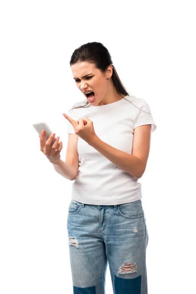 Unzufriedene Frau schreit und zeigt Mittelfinger, während sie Smartphone isoliert auf weiß hält — Stockfoto