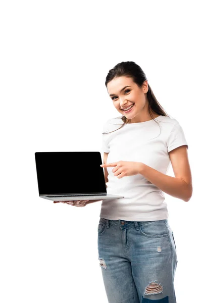Femme brune en t-shirt blanc pointant du doigt sur ordinateur portable avec écran blanc isolé sur blanc — Photo de stock