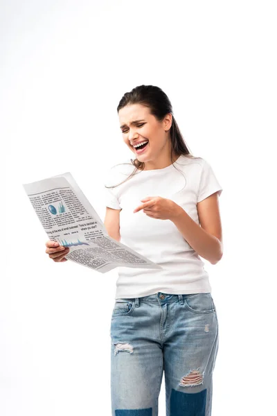 Jovem mulher em t-shirt branca apontando com o dedo para o jornal e rindo isolado no branco — Fotografia de Stock