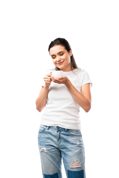 Joven morena mujer en camiseta blanca sosteniendo taza con café aislado en blanco - foto de stock