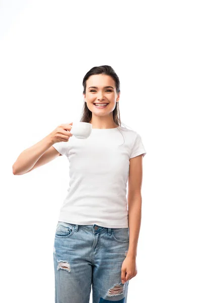 Молода жінка в білій футболці тримає чашку з кавою ізольовано на білому — стокове фото