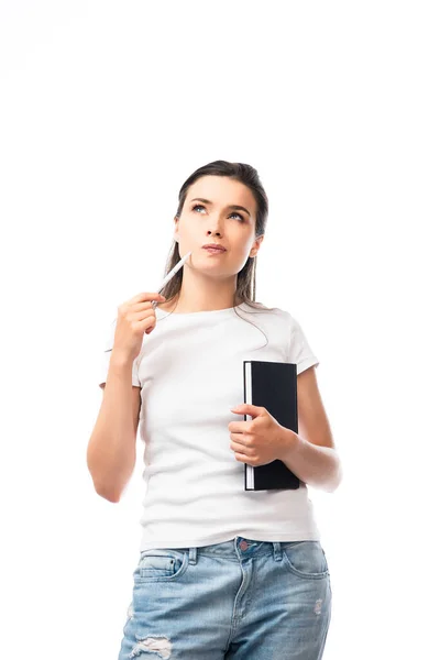 Mujer pensativa en camiseta blanca que sostiene el cuaderno y la pluma aislados en blanco - foto de stock