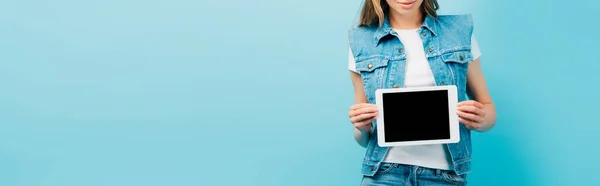 Vista recortada de mulher em colete jeans mostrando tablet digital com tela em branco isolada em azul, conceito panorâmico — Fotografia de Stock