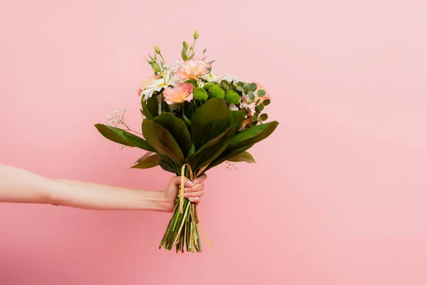 Cropped view of female hand with bouquet of flowers isolated on pink — Stock Photo