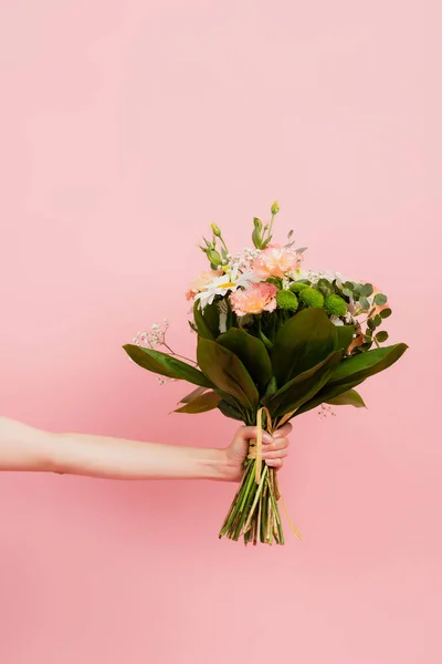 Vista cortada de mulher segurando buquê de flores isoladas em rosa — Fotografia de Stock