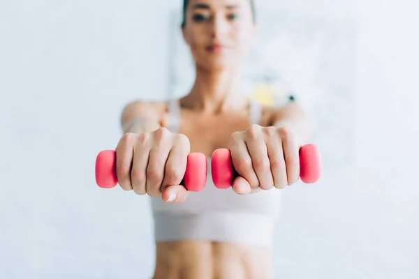 Selective focus of sportswoman training with dumbbells at home — Stock Photo