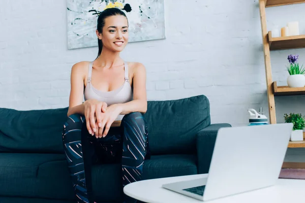 Selective focus of sportswoman looking at laptop during webinar at home — Stock Photo