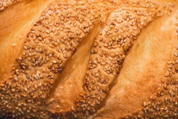 Vista da vicino della crosta di pane appena sfornato con sesamo — Foto stock