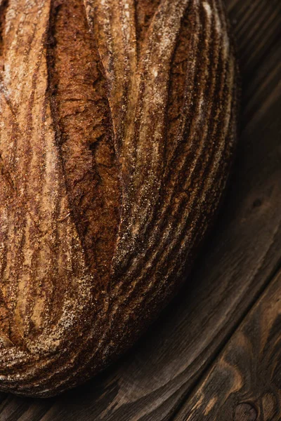 Close up view of fresh baked bread loaf on wooden surface — Stock Photo