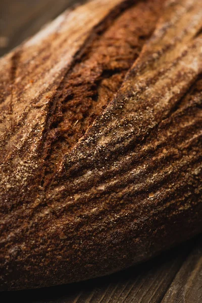 Close up view of fresh baked bread loaf on wooden surface — Stock Photo