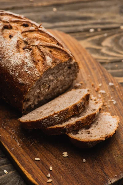 Frisch gebackenes Brot auf Holzschneidebrett schneiden — Stockfoto