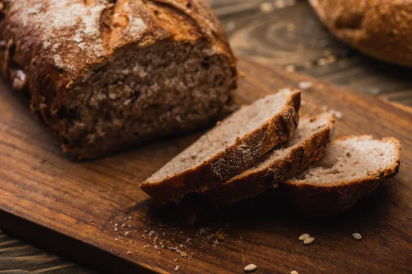 Cortar pão assado fresco na placa de corte de madeira — Fotografia de Stock