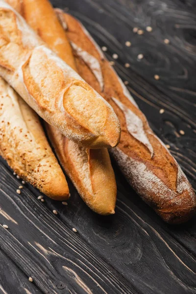 Pagnotte di baguette appena sfornate su superficie di legno — Foto stock