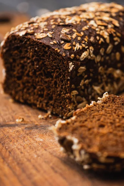 Nahaufnahme von geschnittenem braunem, frisch gebackenem Brot auf Holzplatte — Stockfoto