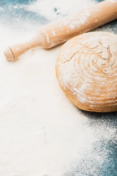 Fresh baked bread and wooden rolling pin on flour — Stock Photo