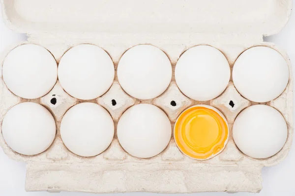 Vista superior de huevos de pollo frescos y yema en caja de cartón - foto de stock