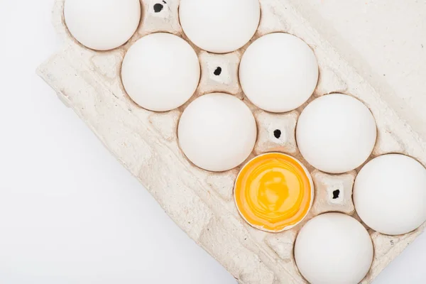 Top view of fresh chicken eggs and yolk in cardboard box isolated on white — Stock Photo