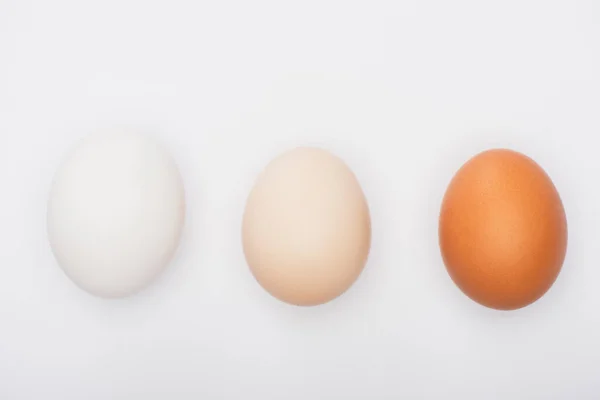 Vue de dessus des œufs de poulet frais colorés isolés sur blanc — Photo de stock