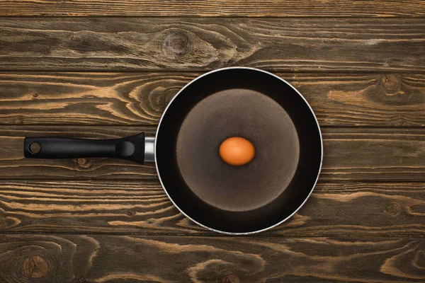 Vista dall'alto dell'uovo di pollo crudo in padella su superficie di legno — Foto stock