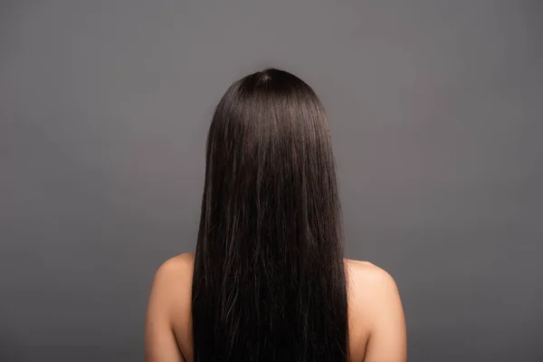 Вид сзади обнаженной брюнетки с длинными волосами, изолированной на черном — стоковое фото