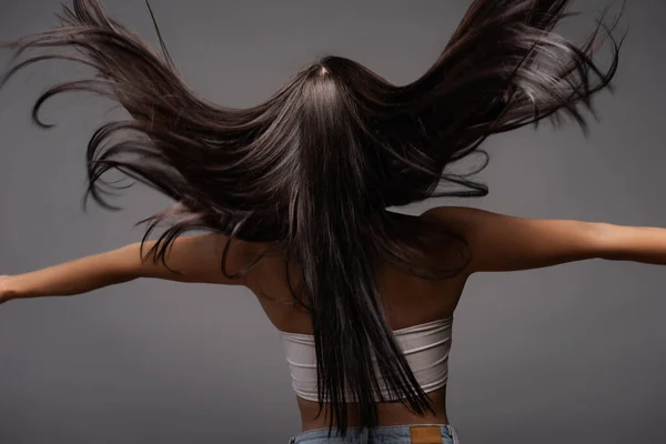 Vue arrière de brunette femme aux cheveux longs isolé sur noir — Photo de stock