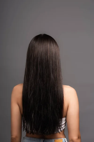 Вид ззаду брюнетки довгошерста жінка ізольована на чорному — стокове фото