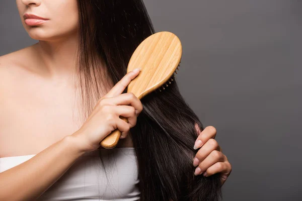 Vista ritagliata di bruna donna spazzolatura capelli isolati su nero — Foto stock