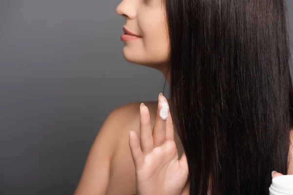 Abgeschnittene Ansicht der brünetten Frau zeigt Haarmaske auf den Fingern isoliert auf schwarz — Stockfoto