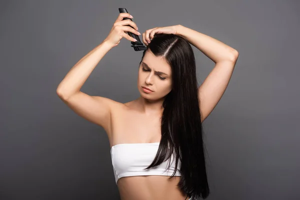 Triste brunette cheveux longs femme rasage tête avec rasoir électrique isolé sur noir — Photo de stock