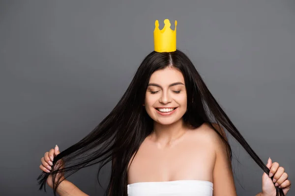 Bruna dai capelli lunghi donna in corona sorridente isolato su nero — Foto stock