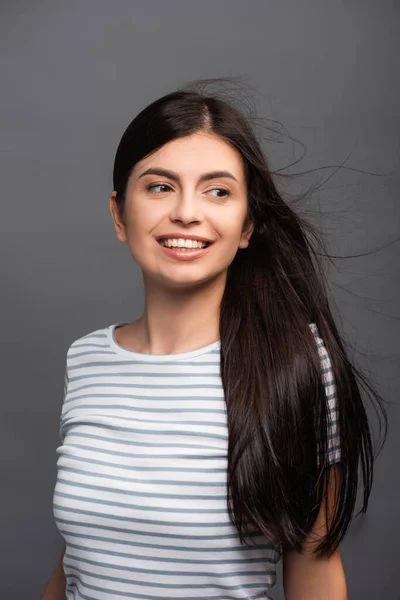 Vent soufflant à travers les cheveux de la femme brune isolé sur noir — Photo de stock