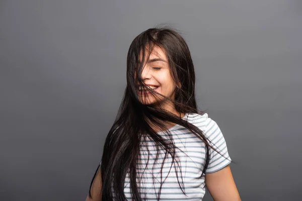 Wind blowing through hair of brunette woman with closed eyes isolated on black — Stock Photo